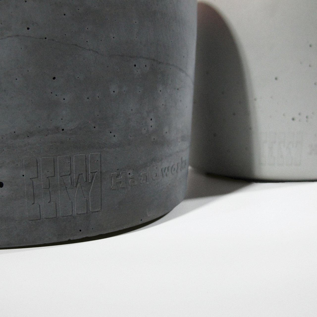 Detailfoto der Handworkz Prägung aus Beton am Fuße der Anthraziten Gartenfackel.