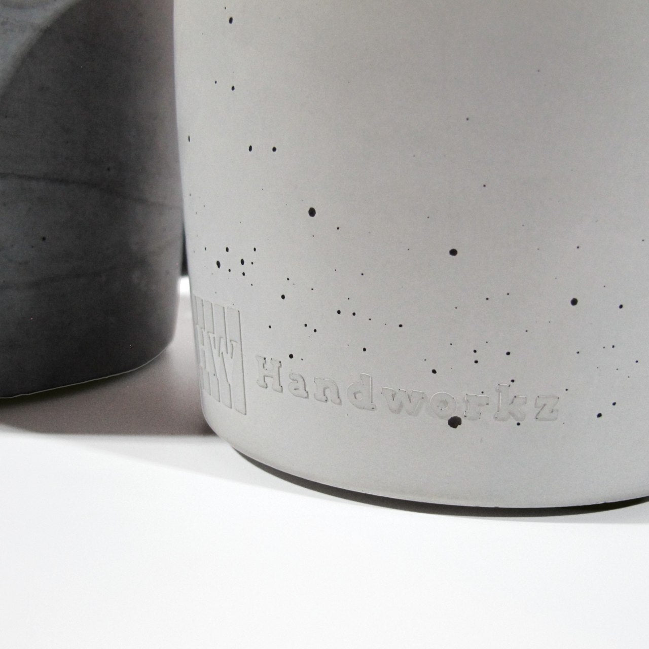 Detailfoto der Handworkz Prägung aus Beton am Fuße der Grauen Öllampe.