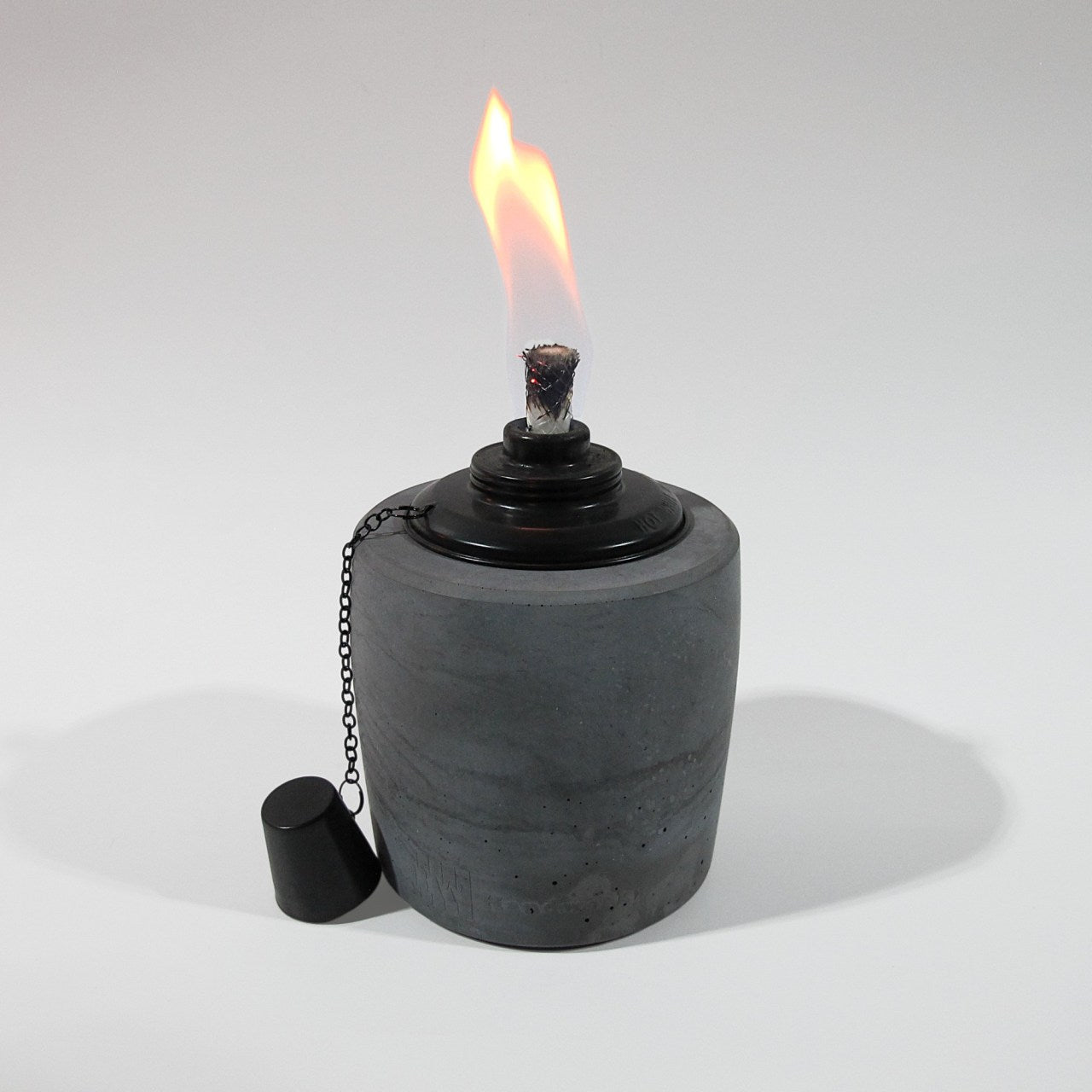 Gartenfackel in Anthrazit mit 13cm Durchmesser und 19cm Hoch. Der schwarze Einsatz des Ölbrenners erzeugt eine schöne gleichmäßige Flame. Der Löschdeckel hängt an einer feinen Kette auf der linken Seite herunter.